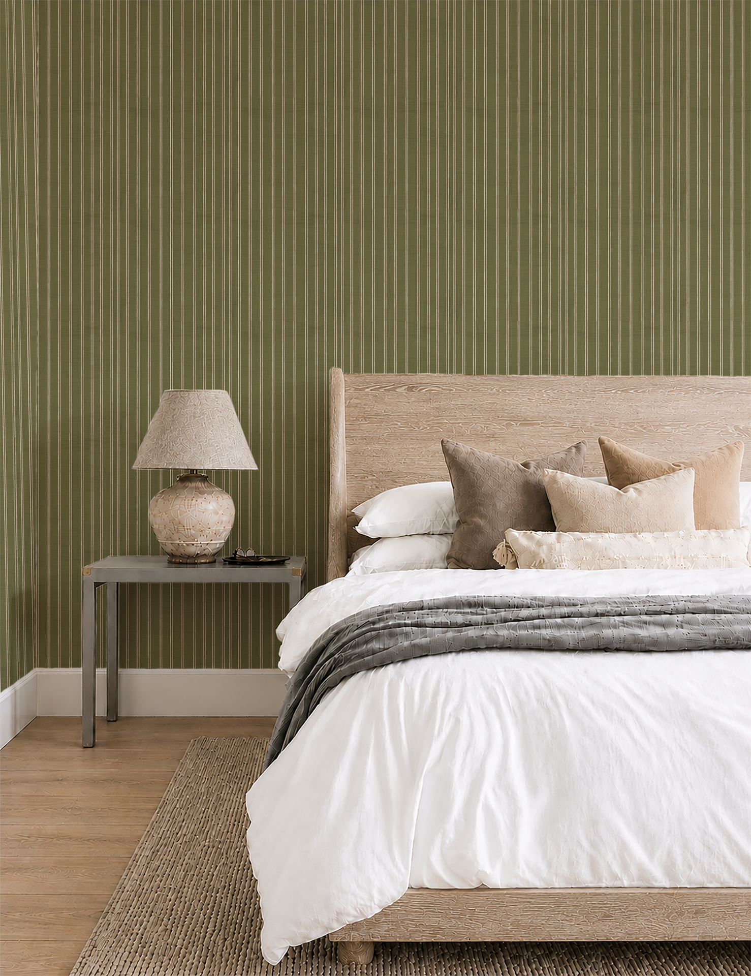 Olive green striped wallpaper in a warm, neutral bedroom with a wooden bed and soft white bedding.